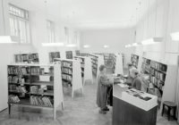 grayscale photography of people inside book store