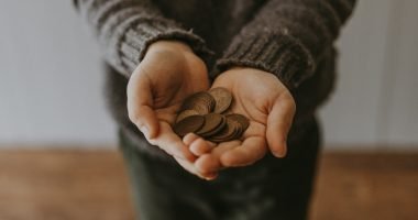 copper-colored coins on in person's hands