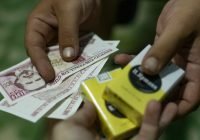 a person putting money into a yellow box